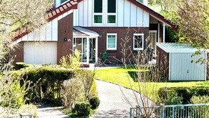 A two-story house with a brick facade, a front porch, and a small attached garage. - House "NordSeeStern", detached, right on the North Sea dike with a fireplace (Wurster Nordseeküste)
