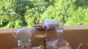 A table set for a meal with various dishes, including cheese, fruit, and a cucumber. - Exclusive vacation apartment | dream location at the foot of the Alps | suitable for allergy sufferers (Füssen)
