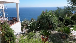 A coastal view with a balcony overlooking the sea, surrounded by various plants and a white building. - Apartment in a beautiful, quiet location with stunning panoramic views across the sea (Velilla-Taramay)