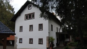 A two-story building with multiple windows and a small entrance. - Romantic holiday home (Dörflis)