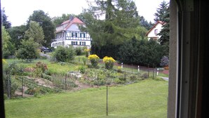 Vista de un jardín con una casa al fondo.
