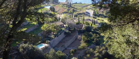 Una propiedad costera con jardines escalonados, piscina y vistas al mar.