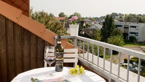A balcony with a table set for two, a bottle of wine, and a book. - Top apartment with 2 bedrooms, balcony and internet flat rate (Grömitz)