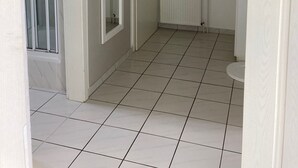 A bathroom with a toilet, a radiator, and a window. - Top apartment with 2 bedrooms, balcony and internet flat rate (Grömitz)