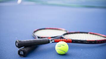 A tennis racket and ball on a blue surface.