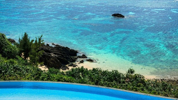 Una piscina con lettini e vista sull'oceano.