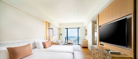 A hotel room with two large beds, a TV, a balcony with a view, and a wooden cabinet.