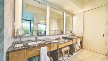 A modern bathroom with marble countertops, dual sinks, and a large mirror.