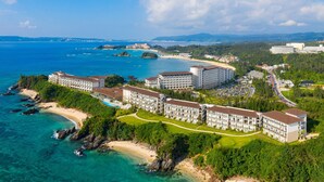Un hotel sul lungomare con diversi edifici, una spiaggia e acque cristalline.