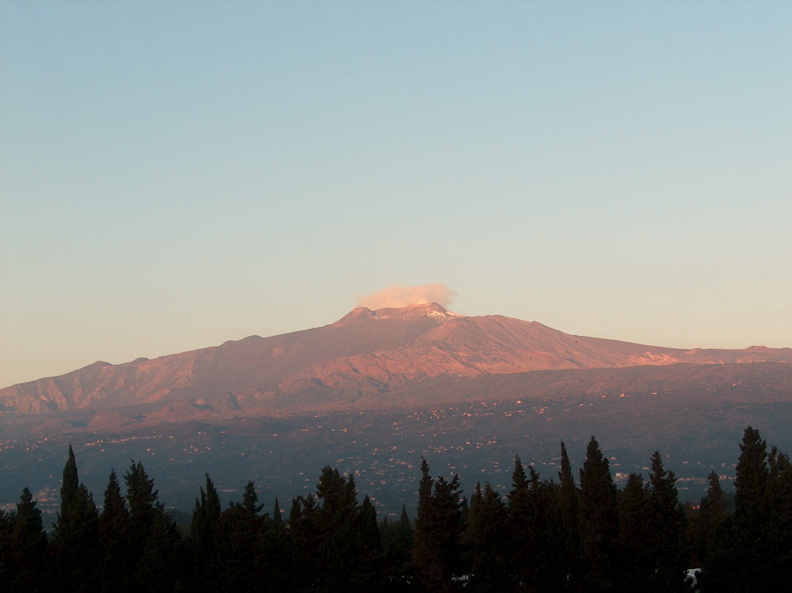 Montaña con cumbre prominente y un primer plano arbolado.