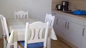 A dining area with a table and chairs, a microwave, and a coffee maker on the counter.