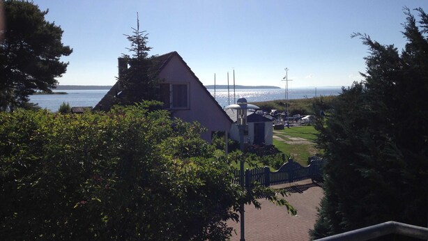A house with a sloped roof, a small attached structure, and a view of the water.
