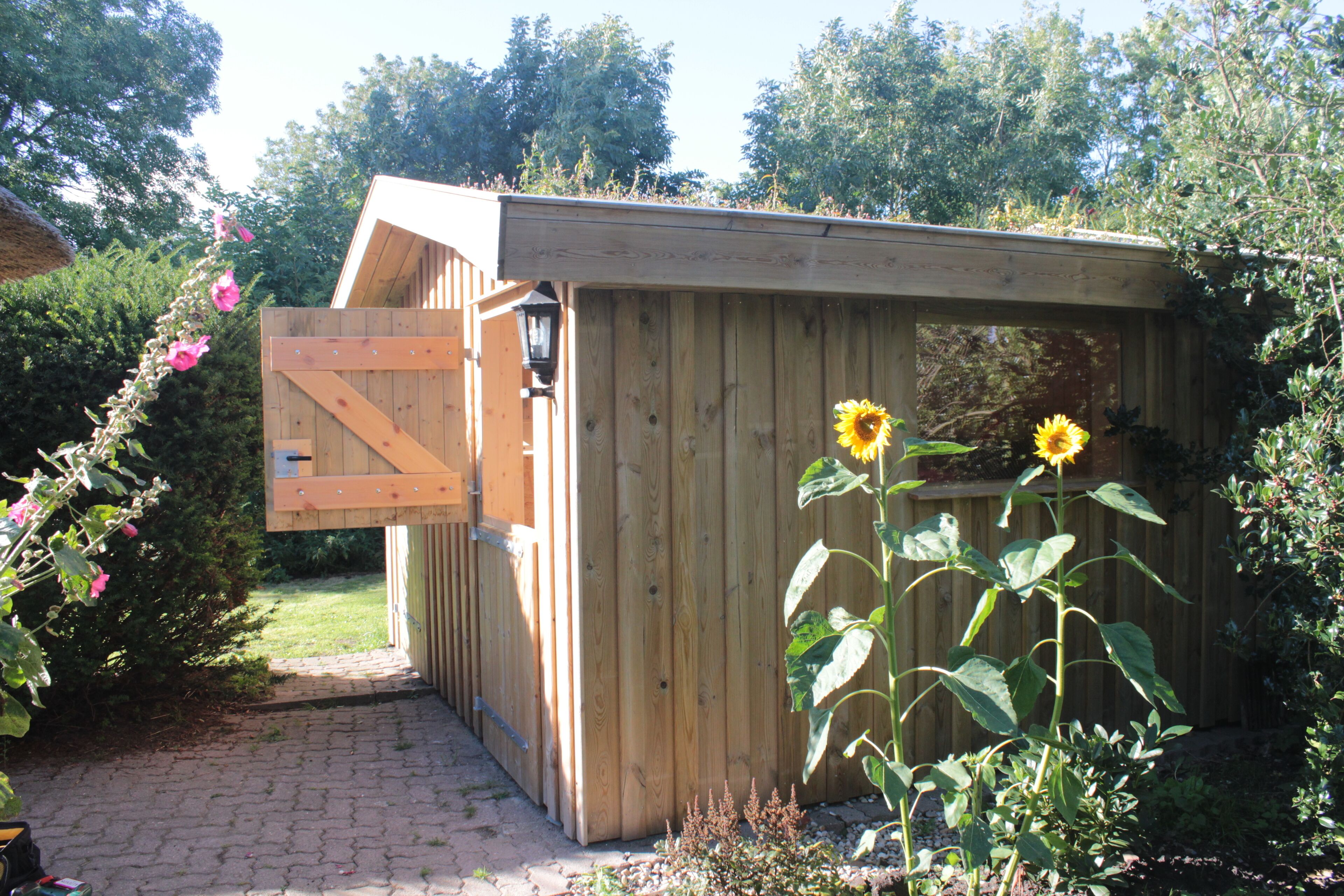A wooden shed with a slanted roof and a door.