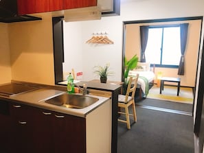 Compact kitchen area with sink and dining space featuring a table and chair.