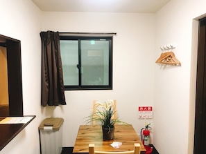 Cozy retreat with a wooden table, potted plant, and window for natural light.