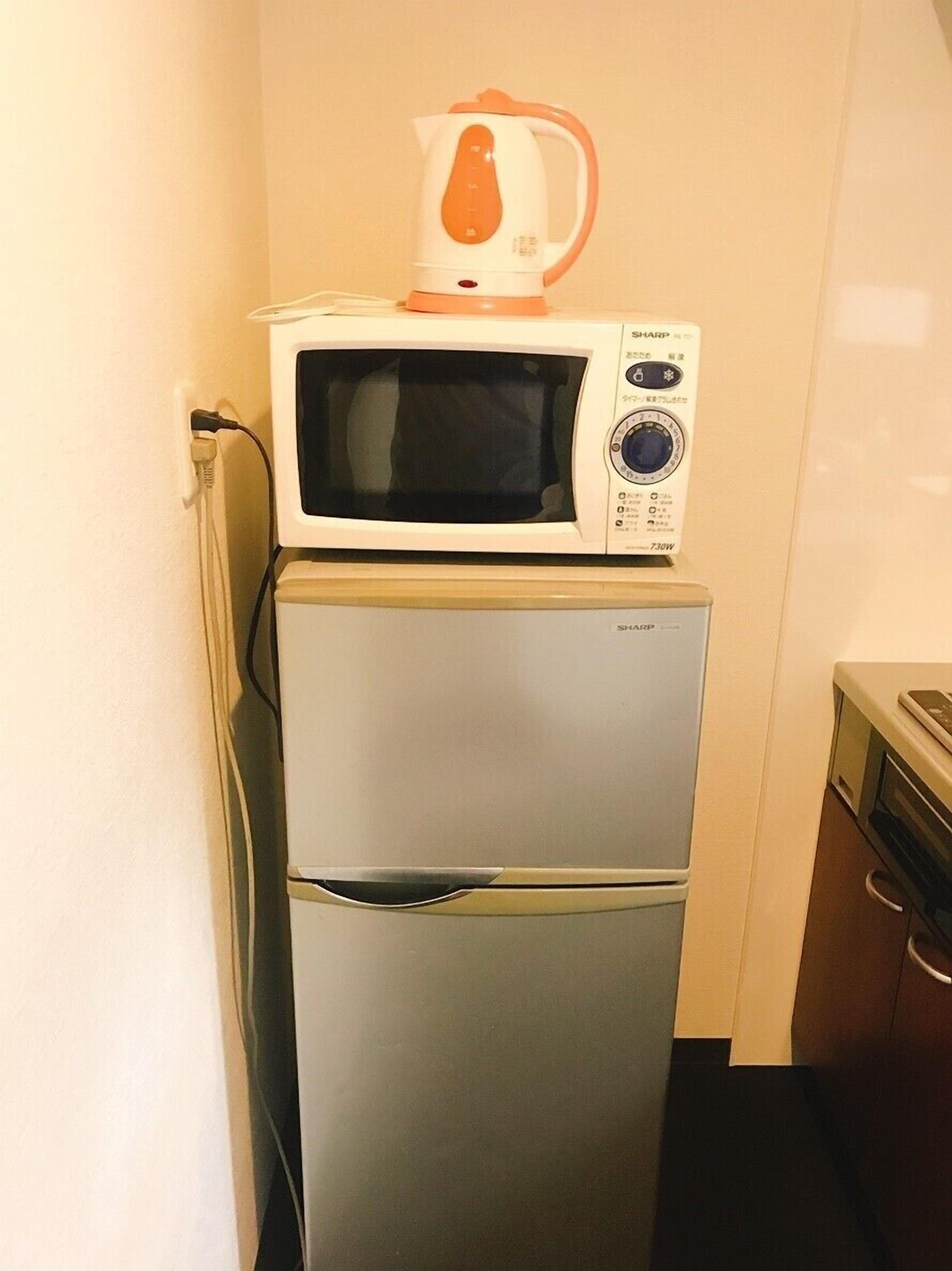 Eine kleine Küche mit Mikrowelle und Kühlschrank.