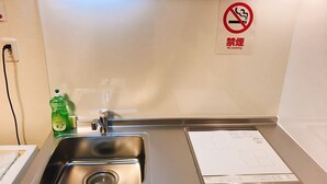 A clean, modern bathroom with a stainless steel sink, a soap dispenser, and a no-smoking sign on the wall. - GH One More Heart at Kamishichiken 3 (Kyoto)