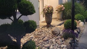 Un jardin bien entretenu, avec une variété de plantes et un chemin de pierre menant à l’entrée d’un bâtiment.