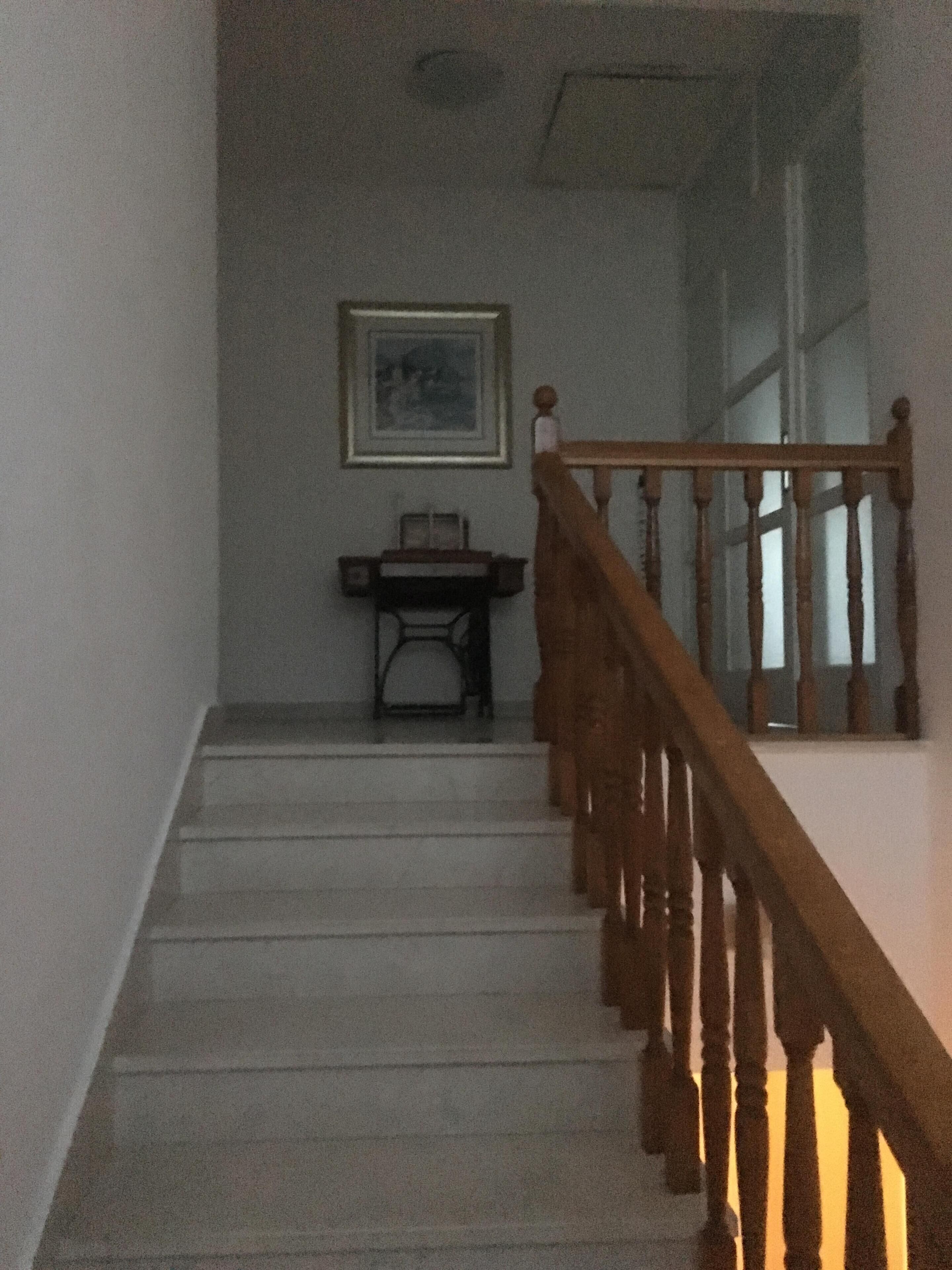 A staircase with wooden railings leading to a landing.