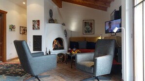 A cozy living room with a fireplace, comfortable seating, and a television. - Rustic modern apartment with atmosphere at Lago Maggiore (Verbania-Biganzolo)