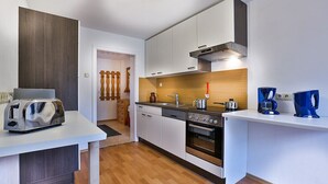 A modern kitchen with white cabinets, a wooden countertop, a built-in oven, and a coffee machine. - Apartment with stunning mountain views - dream vacation in the mountains (Schönau am Königssee)