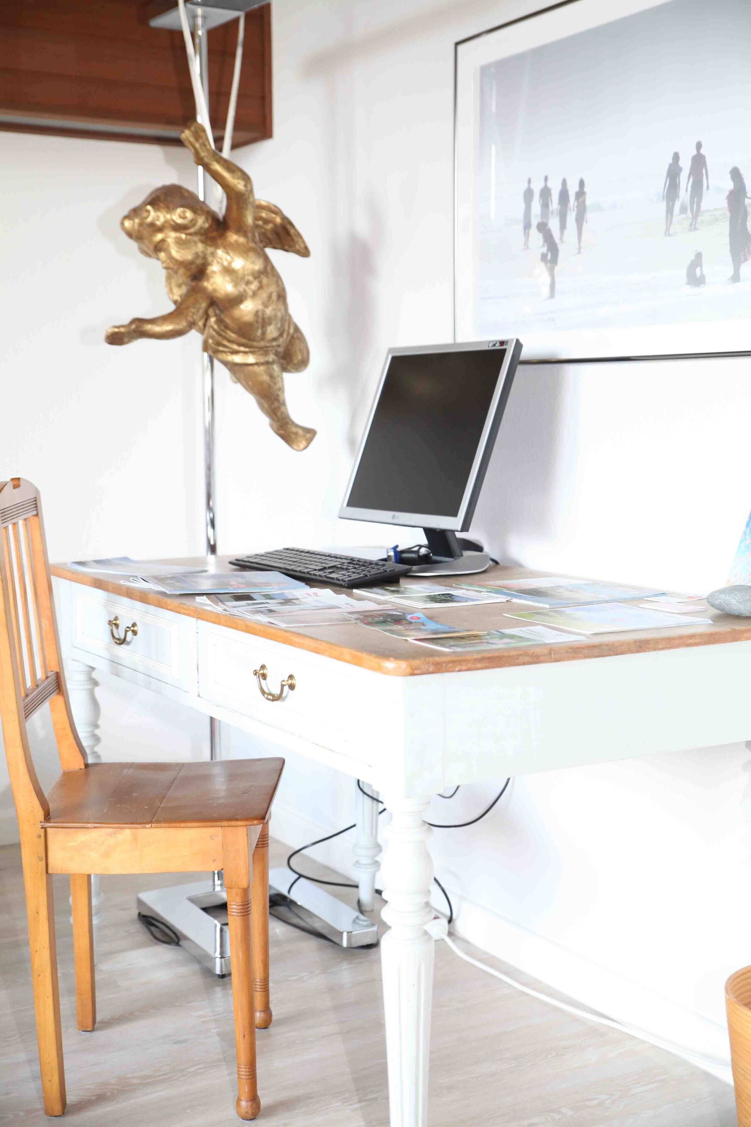 A wooden desk with a computer, a chair, and a scale.