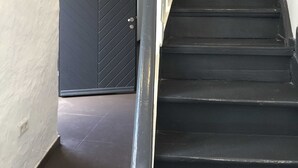 A staircase with black steps and a black door with a diamond pattern. - Apartment Anna for 6 persons - Apartments Rheine Markt 12 (Rheine)