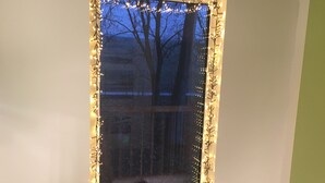 Ein Fenster mit Weihnachtsdeko und Lichterkette.