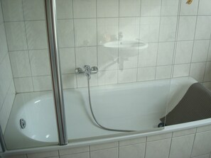 A bathroom with a bathtub, a shower, and a sink. - Apartment at the foot of the Teutoburg Forest  (Sandebeck)