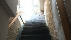 A staircase with wooden steps leading upwards, surrounded by rough stone walls. -  Freckle, bed & bike (Betina,Murter)