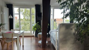A modern room with a bed, a desk, a chair, and a large window. - Attic studio in the Geteviertel - close to the city, trade fair, university, stadium and Weser cycle path (Schwachhausen)