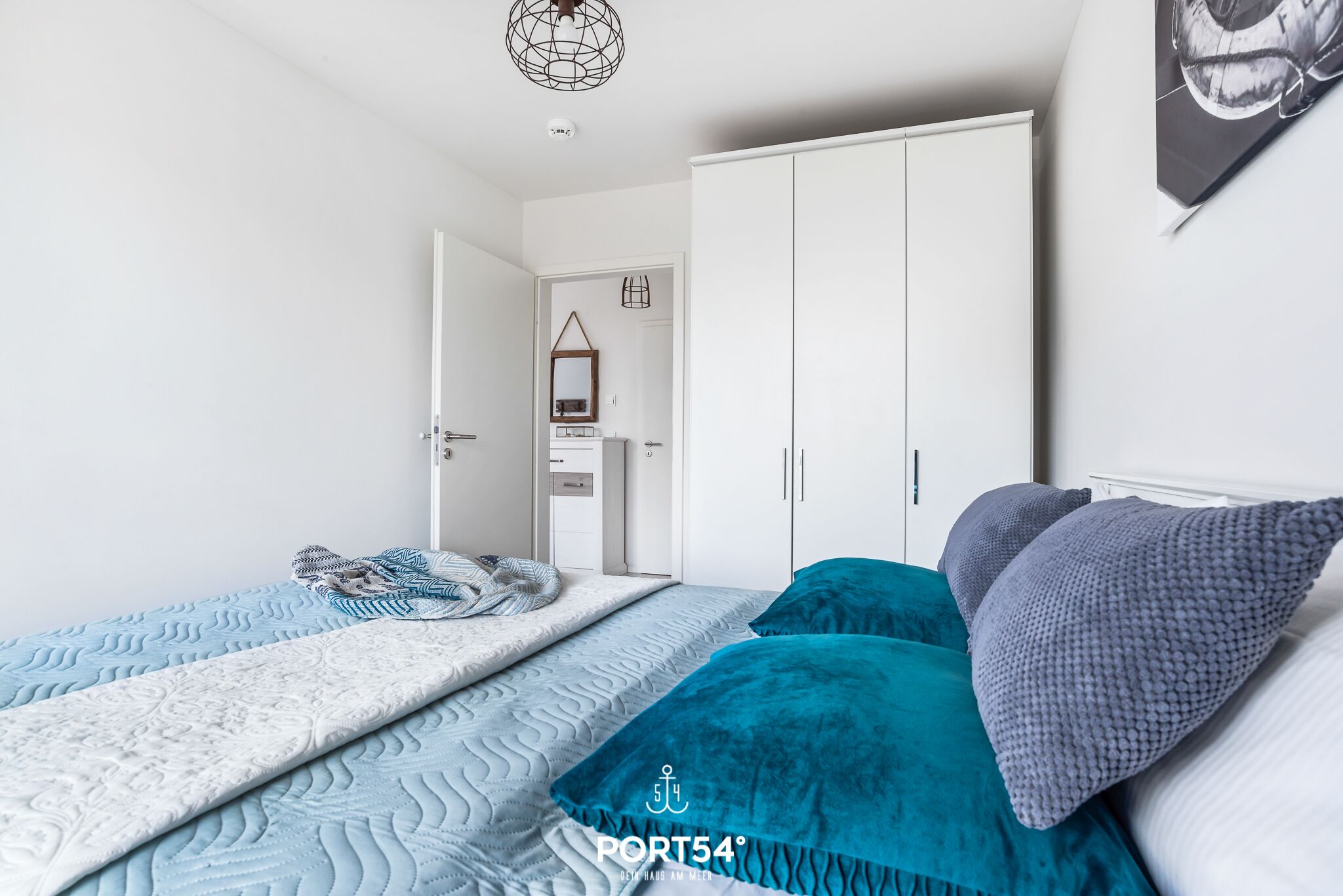 Ein Schlafzimmer mit Bett, Kleiderschrank und einer Tür zum Badezimmer.