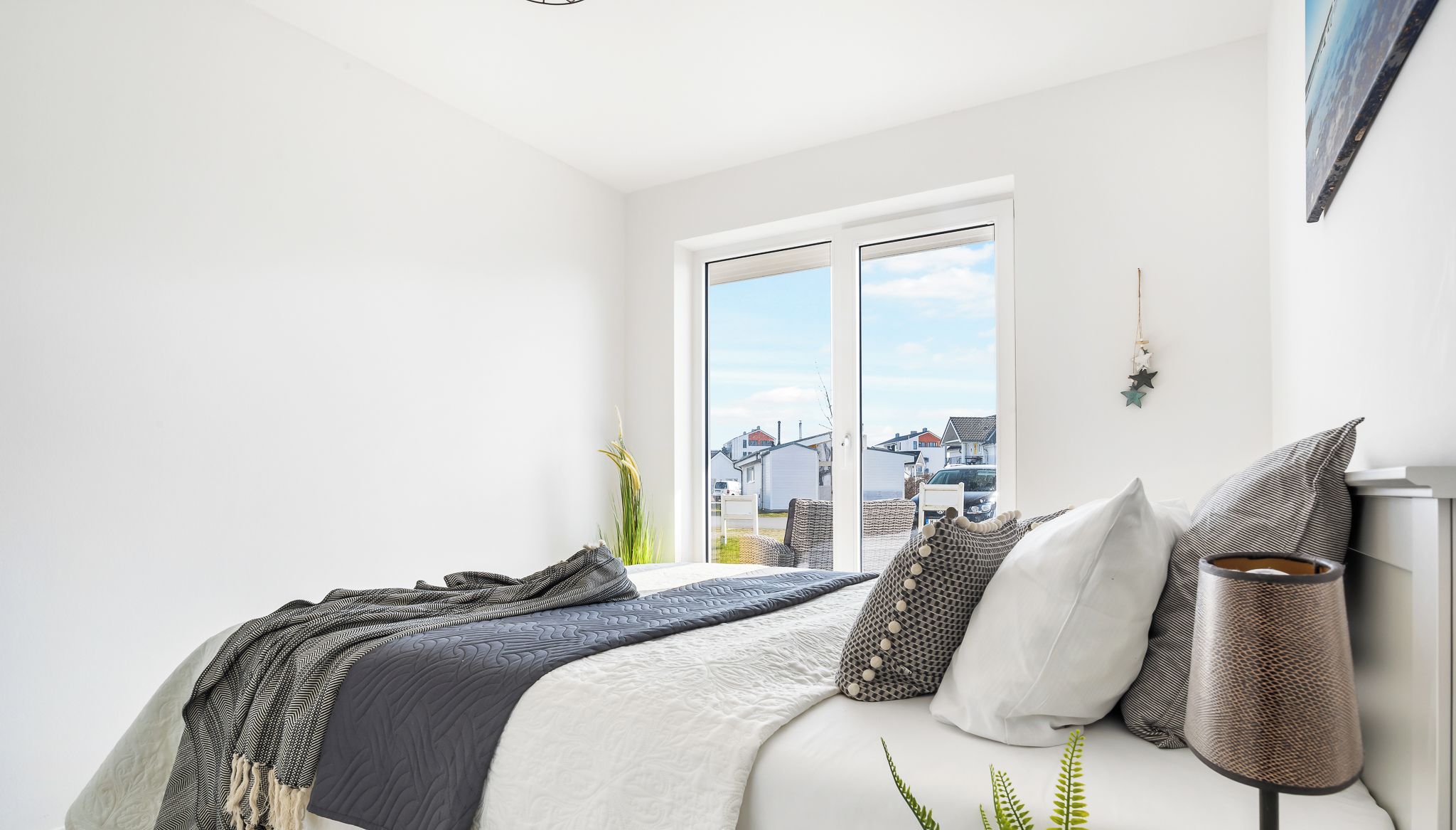 Une chambre à coucher avec un lit, une fenêtre et une plante.