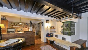 A rustic interior with a wooden bar area, stone walls, and a cozy seating area with a fur throw.