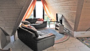 Ein gemütliches Wohnzimmer mit zwei Ledersofas, einem kleinen Tisch und einem Kamin.
