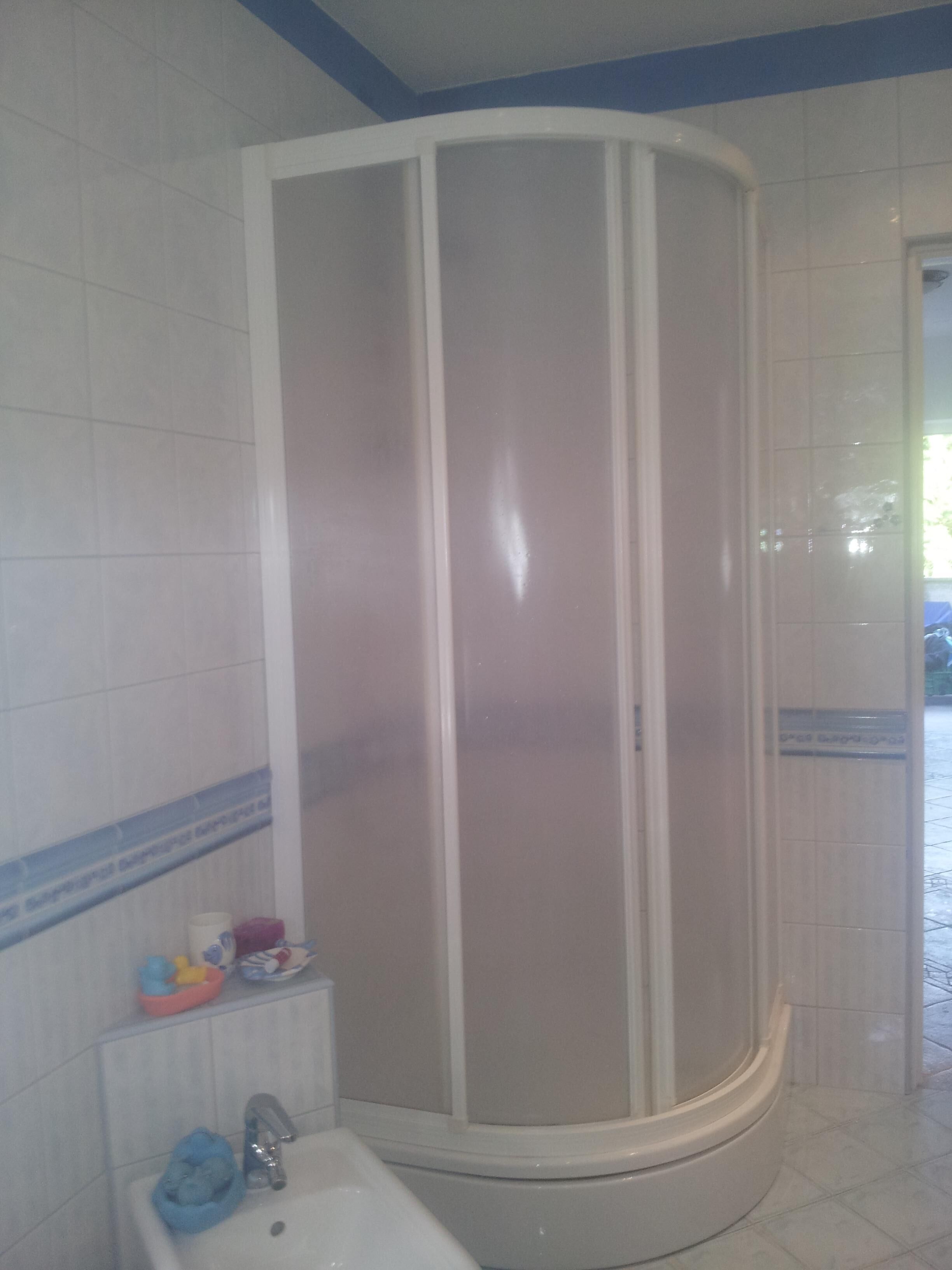 Un bagno con doccia, lavandino e servizi igienici.