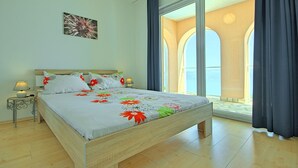 A bedroom with a bed, a nightstand, a lamp, and a large window with curtains. - Holiday house with fantastic sea view and pool - spring offer from 27. 4.-19. 5th (Ripenda Kosi)
