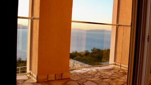 A balcony with a stone floor, a glass railing, and a view of distant mountains. - Holiday house with fantastic sea view and pool - spring offer from 27. 4.-19. 5th (Ripenda Kosi)