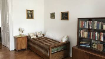 A room with a wooden bed, a nightstand, a bookshelf, and a door.