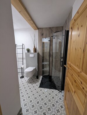 Een douche, een haardroger, handdoeken, toiletpapier