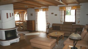 Ein gemütliches Wohnzimmer mit Kamin, einer Couch, einem Couchtisch und einer Lampe.