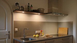 Una cocina moderna con un lavaplatos integrado, encimera de madera y campana extractora de acero inoxidable.