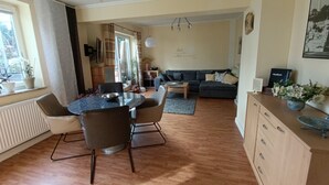 Een moderne woonkamer met een eethoek, een bank en een salontafel.