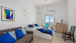 A modern bedroom with a bed, a sofa, and a wooden cabinet. - Lovely apartment in Stinica with house sea view (Stinica)