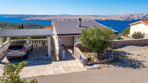A coastal property with a covered carport, a stone wall, and a view of the sea. - Lovely apartment in Stinica with house sea view (Stinica)