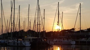 A marina with multiple sailboats docked at sunset. - Detached holiday home in a quiet location, right on the Grevelingenmeer (Herkingen)