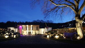 A building with a stone facade, a large tree in front, and a zebra sculpture. - Holiday house at the lake *Pets*Art*Raft* Golf *Bathing lake*Canoe*Idyll (Crivitz OT Basthorst)