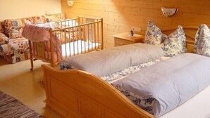Un dormitorio acogedor con una cama litera de madera, una mesita de noche pequeña y una mesilla.