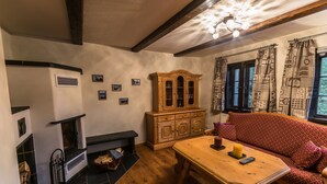 Una sala de estar acogedora con chimenea, un aparador de madera y un sofá estampado.