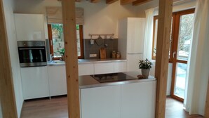 Eine moderne Küche mit weißen Schränken, einem eingebauten Backofen und einer zentralen Kochinsel.